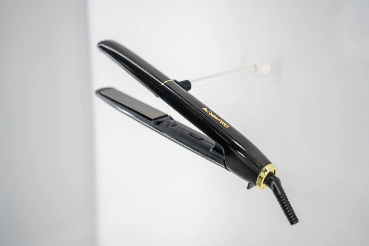 Egy fekete és arany hajegyenesítő kerámia laposokkal.