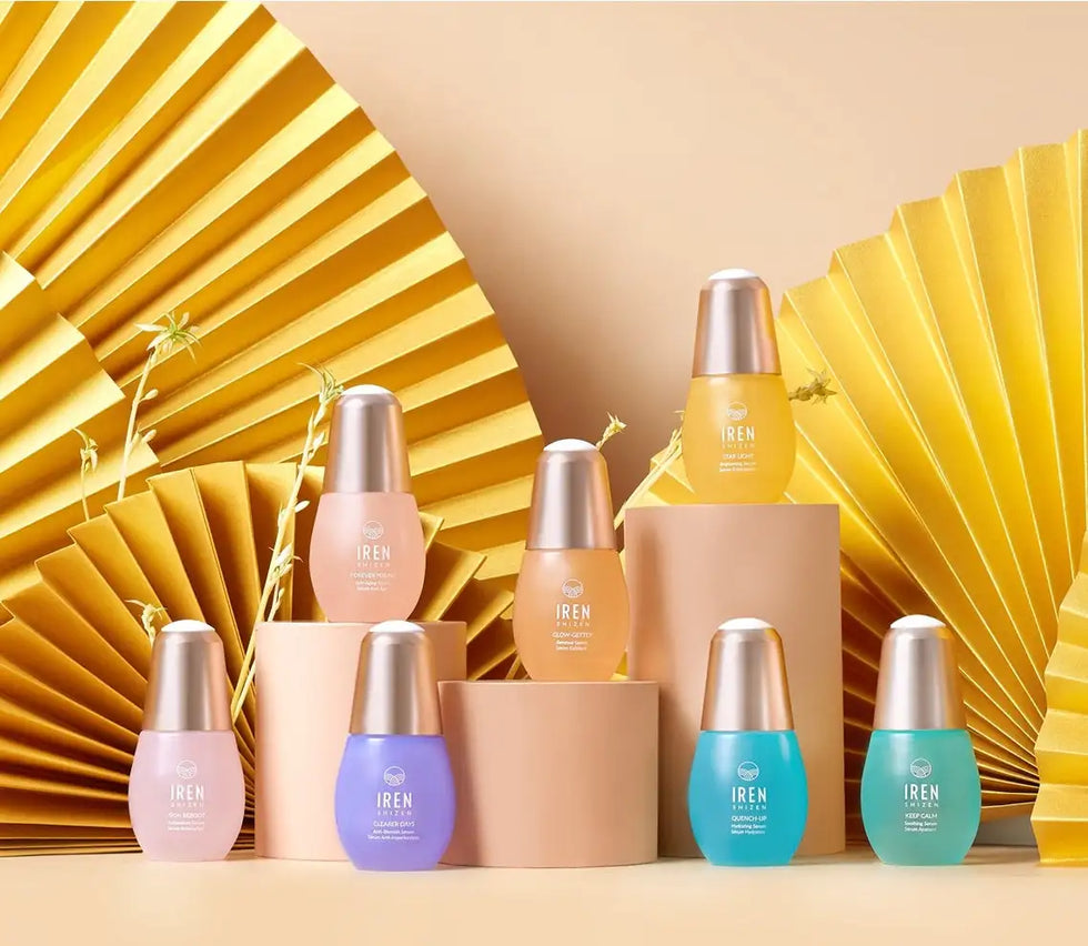 Rózsaszín és lila üvegpalackok arany kupakkal, iren bőrápolási vonal.