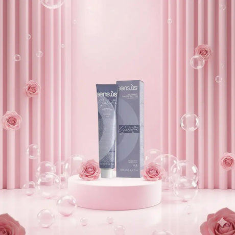 Egy elegáns, matt szürke tubus a sens.tis gualtatti ultimate haircolor system melletti áll a hozzá illő dobozával egy puha rózsaszín talapzaton.