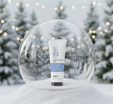 Fehér tubus puring 03 rehab restructuring curl multitraction maszk kék címkével és ezüst levél logóval, hóglobusban elrejtve.