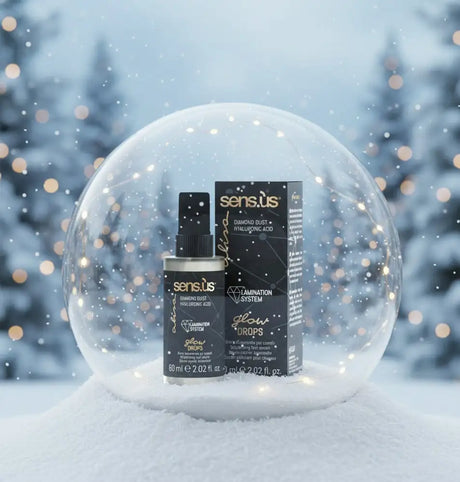 A Sens.us glow cseppje egy elegáns fekete spray üvegben arany betűkkel, a hozzá illő doboz mellett elhelyezve egy átlátszó hógömb belsejében.